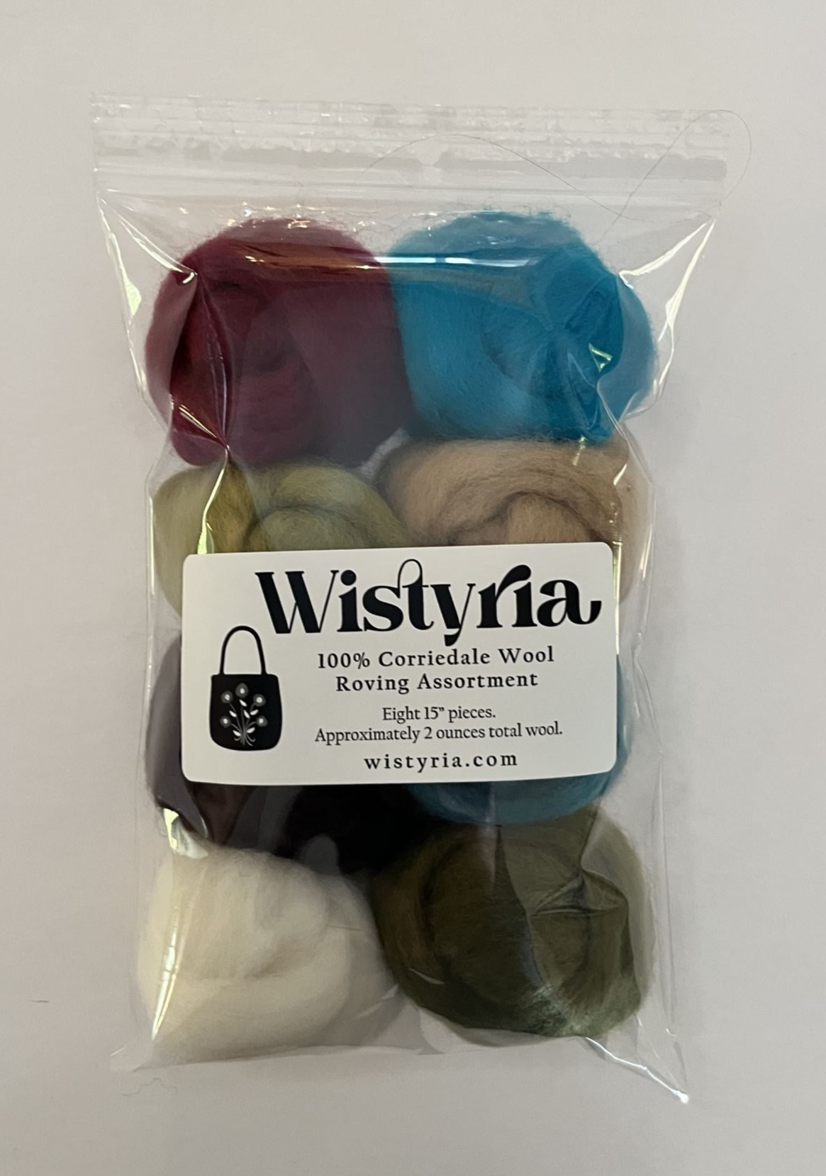 Colorful wool roving assortment in raspberry, turquoise, lima bean, camel, chocolate, teal, natural, olive, shown in package on a light background.